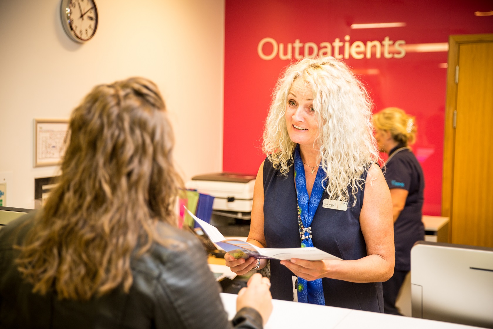 patient at reception desk in outpatients