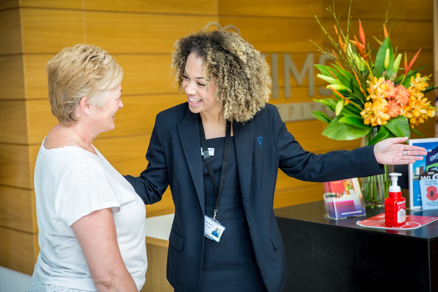 receptionist greeting patient at KIMS Hospital main entrance
