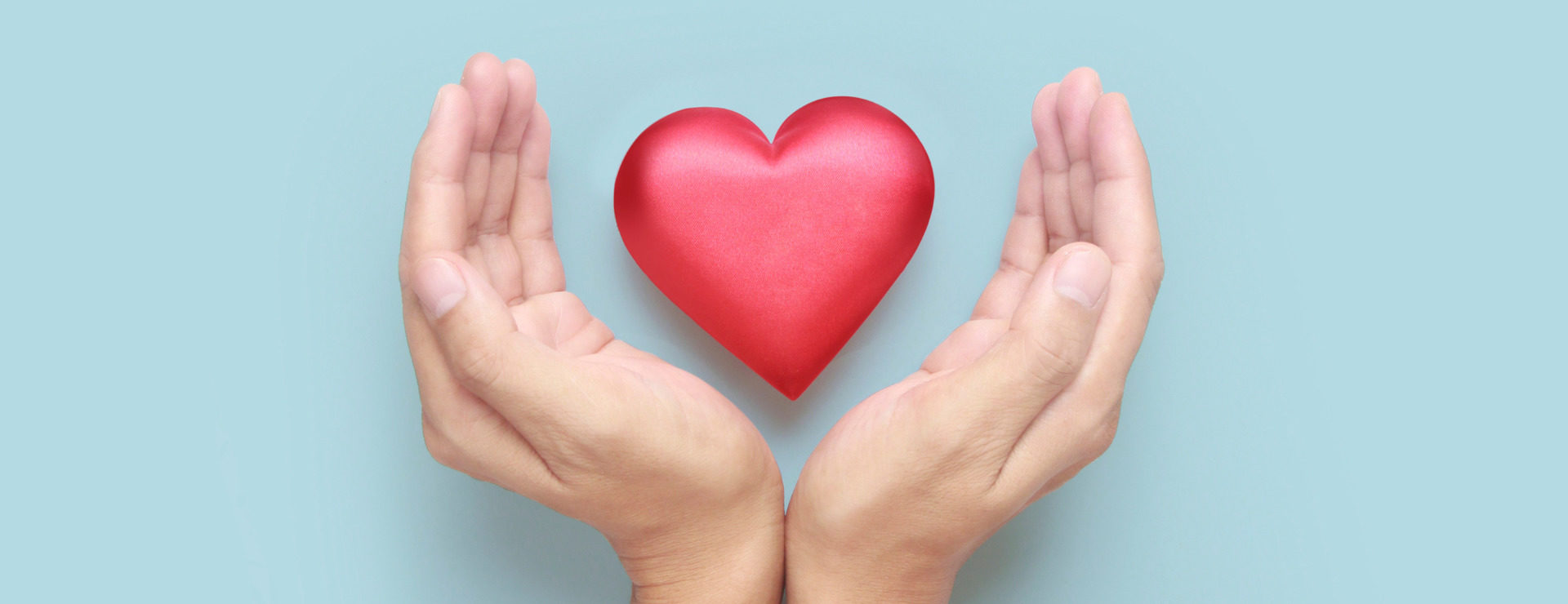 A 3D heart held between two hands promoting heart health through specific diet and lifestyle management tips.