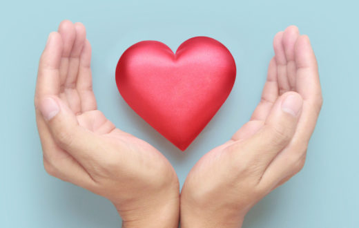 A 3D heart held between two hands promoting heart health through specific diet and lifestyle management tips.
