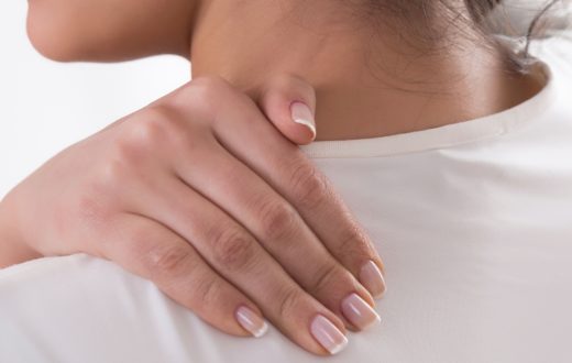 Close up of patient holding shoulder to relieve shoulder pain