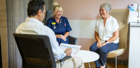 A Consultant talking a patient through their test results with a Nurse as a chaperone.
