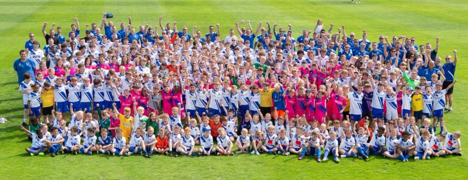 Large group photo of Bearsted FC players on a pitch celebrating their 2025/26 partnership with KIMS Hospital.